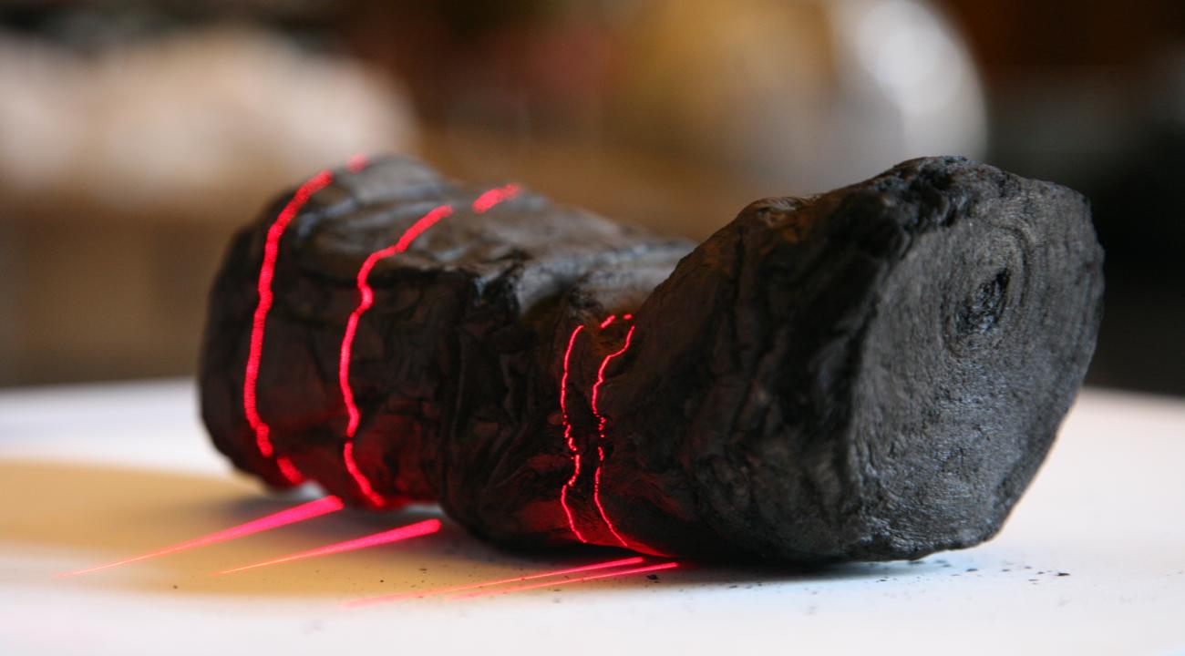 scrollscanredlines black carbonized scroll with red laser lines shining on it